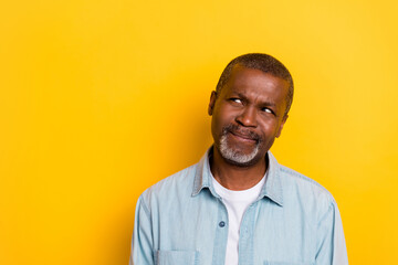 Portrait of minded intelligent creative person look interested empty space isolated on yellow color...