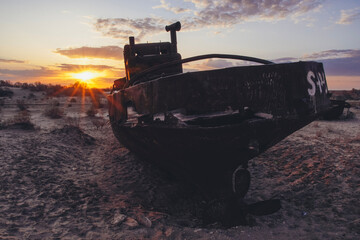 Cemetery of old ships on the former bank of Aral sea during sunrise, Muynak, Uzbekistan