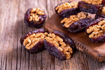 Walnut-stuffed dates on a wood floor. Close-up. Arabian luxury for special occasions such as Ramadan and Eid holidays. local name cevizli hurma