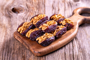 Walnut-stuffed dates on a wood floor. Close-up. Arabian luxury for special occasions such as Ramadan and Eid holidays. local name cevizli hurma