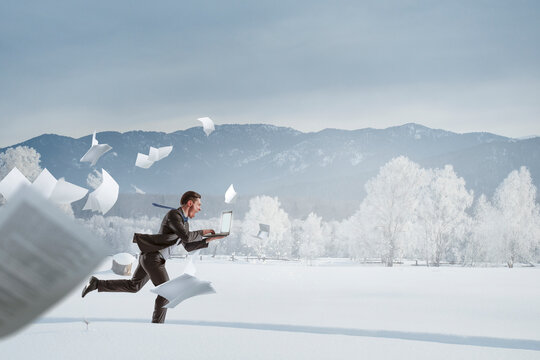 Businessman running in winter countryside