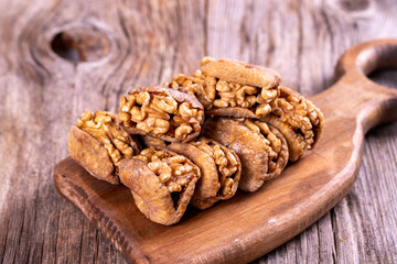 Stuffed dried figs. Dried figs stuffed with walnuts on a wood floor. Close-up. local name cevizli incir