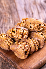 Stuffed dried figs. Dried figs stuffed with walnuts on a wood floor. Close-up. local name cevizli incir