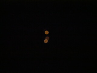 mysterious small, luminous orange circles on a black background © TK_Office