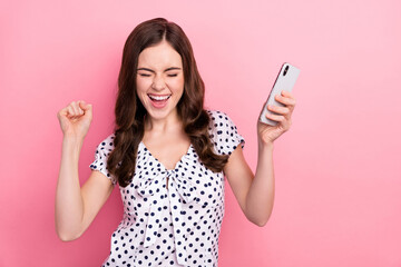 Photo of funky overjoyed girl raise fists in victory win in social media phone giveaway isolated on pink color background - obrazy, fototapety, plakaty