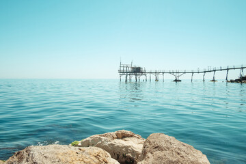 Trabocchi Coast in Italy. Wooden house and pier on the beautiful crystal clear blue water of the Adriatic Sea