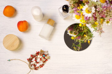 Cosmetic bottles, fruit flowers and mirror on table, lifestyle staging