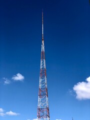 Obraz premium Telecommunication tower under a natural blue sky background in sunny day
