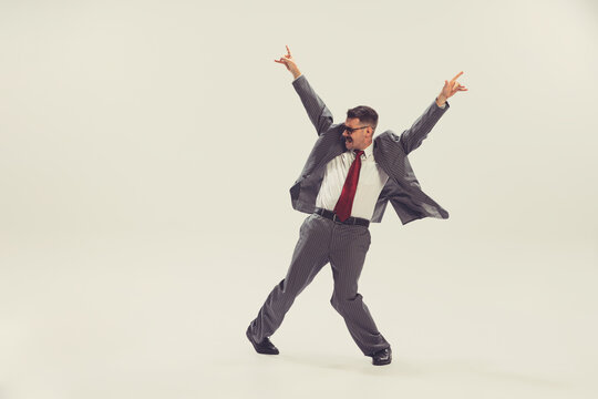 Portrait Of Young Man, Businessman Dressed In Suit In 50s, 60s Fashion Style Dancing Isolated On White Background. Retro Vintage Style, Business, Ad, Emotions