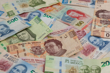 Background of Mexican pesos bills of different denominations - obrazy, fototapety, plakaty