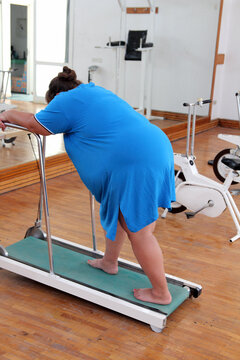 overweight woman running on trainer treadmill