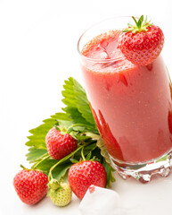 glass with strawberry juice, berries and strawberry leaves and ice cubes on white background