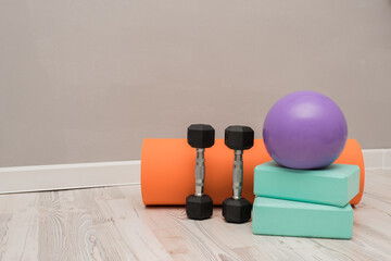 The concept of yoga, home exercises, healthy lifestyle and fitness. Dumbbells, yoga mat, balls