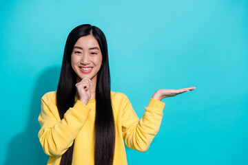 Photo of clever pretty woman wear yellow pullover arm chin holding arm empty space isolated teal...