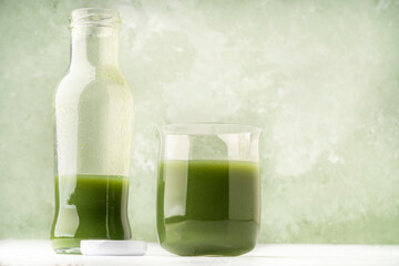 bottle and glass of fresh green detox smoothie drink
