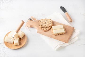 cheese slices on thin crispy crossbred or fibre crackers on wooden cutting bread board