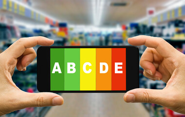 hands holding a smartphone in a grocery store with a Nutriscore label on screen