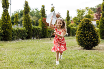 little cute girl with paper airplane outdoor - 509817539