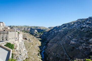 Fototapeta premium Panorama della città di Matera in Basilicata, punto d'arrivo del Cammino Materano, e della sua gravina