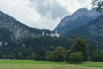 Castle in the mountains, Bavaria Alps with castle, Beautiful view in Alps in summer, neuschwanstein castle view, View in Bavaria Alps, Famouse white Castle in Germany, Fairytale Building - obrazy, fototapety, plakaty