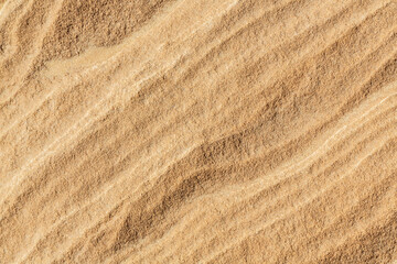 Fototapeta na wymiar Close-up texture with lines on orange sand in Sinai desert, Sinai peninsula, Egypt