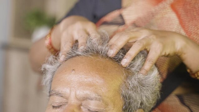 close up shot of wife doing head masage to husband at home - concept of senior couple lifetsyle, therapy.