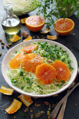 Cabbage salad with orange and pistachio on darktable. Top view with copy space. Healthy food.