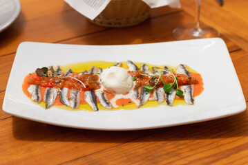 Anchovy fillets (freshly salted) in olive oil and fresh tomato tartare with a scoop of cream cheese