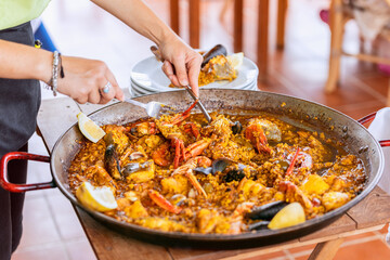 Serving of traditional spanish seafood paella from the fry pan with mussels, langoustine and fish