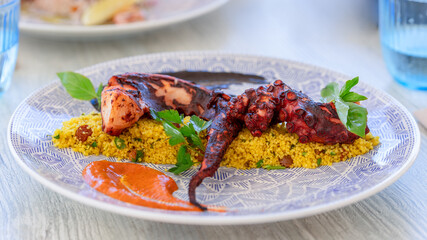 Aromatic couscous with sweet raisins and grilled octopus tentacles