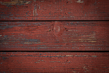 Old natural weathered wooden planks with cracked red paint background