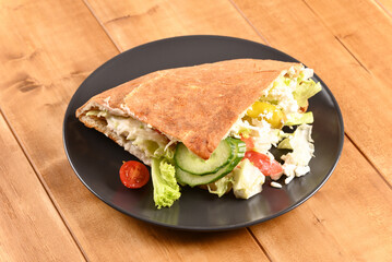 Doner kebab on a dark plate.