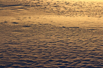 Shiny snow in frosty weather during sunset, winter background