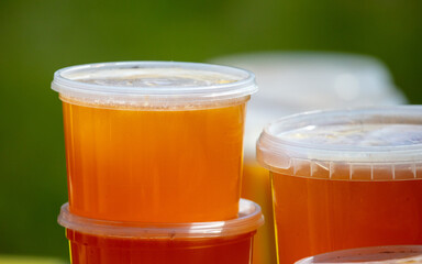 Honey in plastic jars in nature.