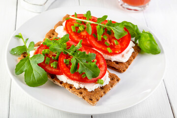 Crispbread with curd cheese, tomatoes, green onions, arugula and basilica. Delicious and healthy...