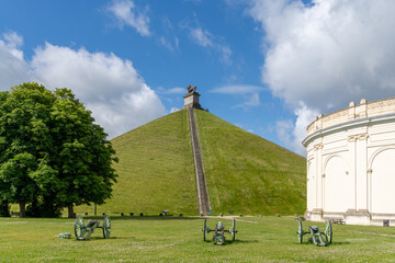 view of the Lion's Mound and cannons at the Waterloo Battlefield Memorial outisde of Brussels - obrazy, fototapety, plakaty