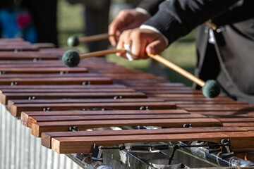 Xylophone keys with musician's hands playing the instrument.