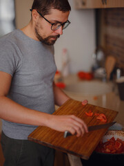 man preparing homemade tomato sauce for pizza or pasta. happy satisfied male preparing vegetarian snacks, food for dinner or party, enjoying leisure time, hobby.