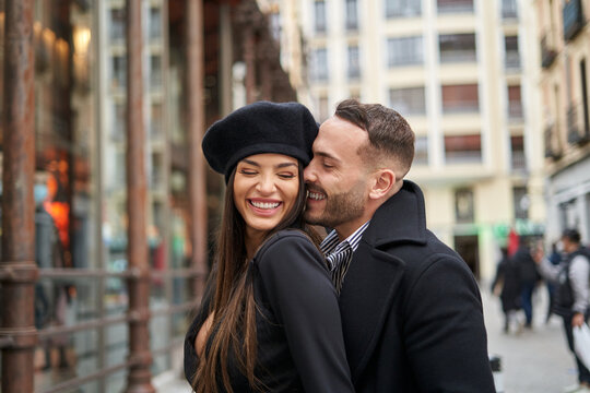 Cheerful couple caressing on street