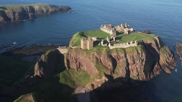 beautiful distant circular birds eye view of dunnottar castle on the rock in the scottish stonehaven bading in the sunlight