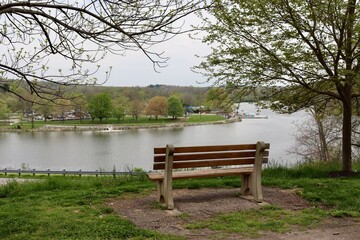 The empty park bench overlooking the lake in the park.