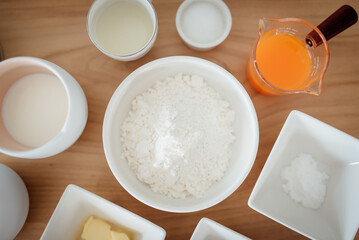 A set of ingredients and tools for baking an orange cake.