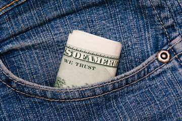 Dollars in the pocket of blue denim pants close up