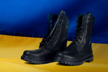 Army shoes on the background of the flag of Ukraine. The concept of mobilization.