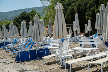Beach umbrella and sun lounger chairs closeup in sunny day