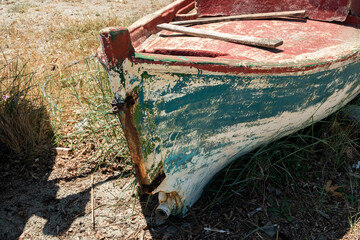 Old weathered vintage fishing boat front side on beach ground
