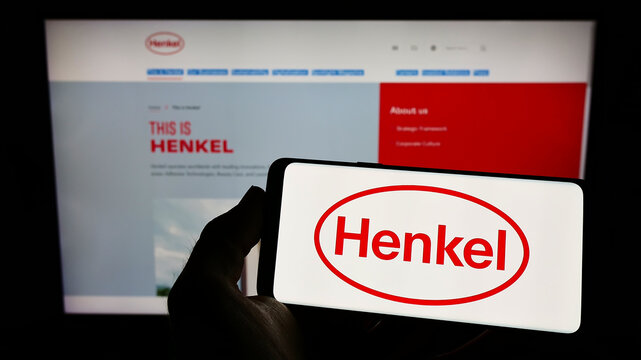 Stuttgart, Germany - 06-04-2022: Person holding smartphone with logo of consumer goods company Henkel AG Co. KGaA on screen in front of website. Focus on phone display.