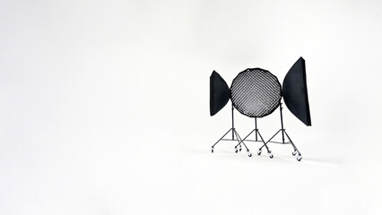 Three studio lights of softbox and octobox stand against background of white cyclorama in...
