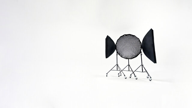 Three studio lights of softbox and octobox stand against background of white cyclorama in photostudio