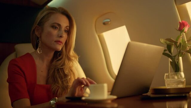 Closeup rich woman working laptop computer. Relaxed lady take break enjoy coffee